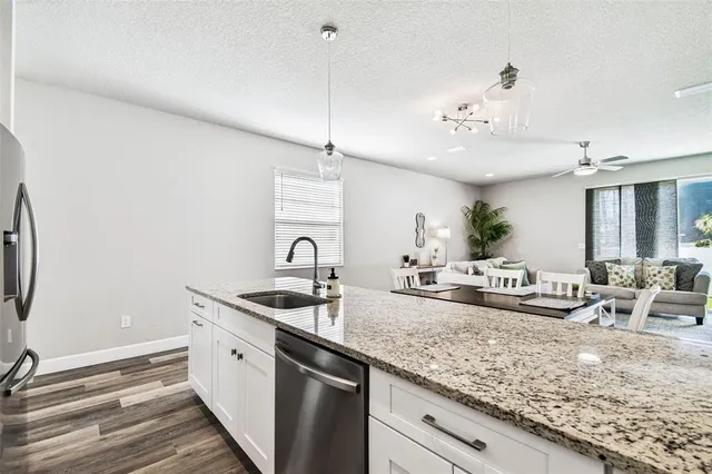 a kitchen with sink stove and living room