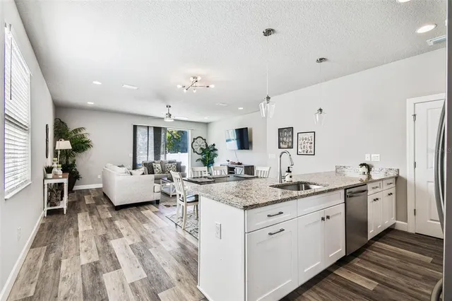 a open kitchen with stainless steel appliances granite countertop a lot of counter space and wooden floors
