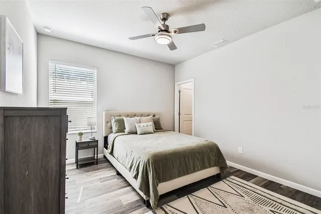 a bedroom with a bed and a ceiling fan