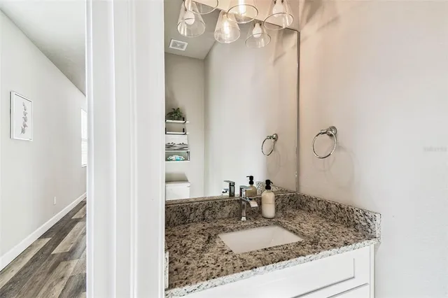 a bathroom with a granite countertop sink a mirror and shower
