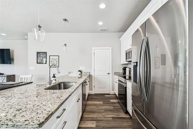 a kitchen with stainless steel appliances granite countertop a refrigerator and a sink