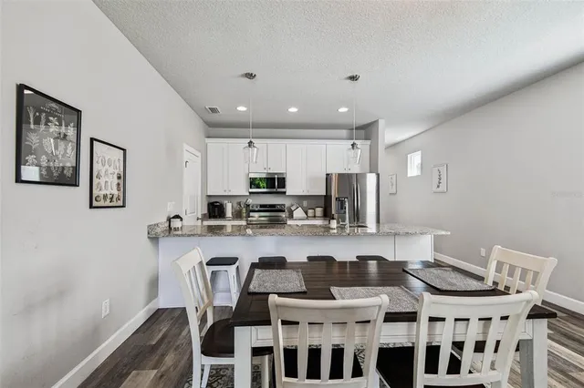 a large kitchen with a table and chairs