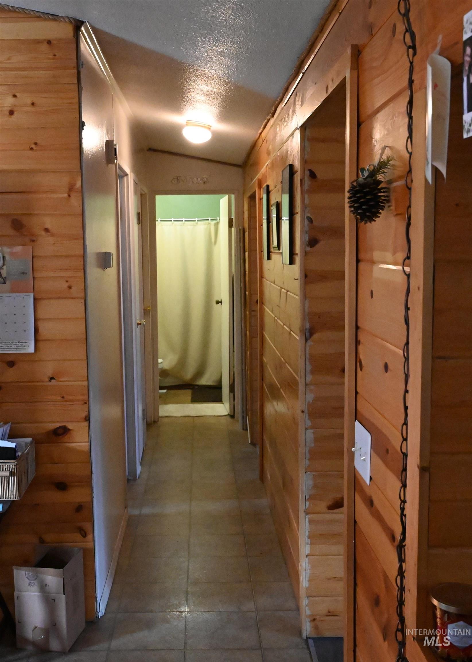 32288 Amos Bench Road Lenore, ID 83541 - Photo 8 of 24 Hall with wood walls and a textured ceiling