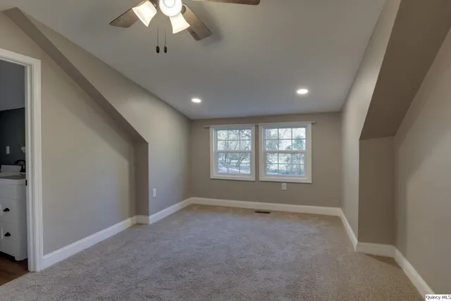 en empty room with windows and ceiling fan
