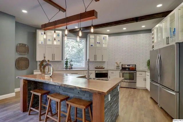 a kitchen with granite countertop a sink appliances and cabinets