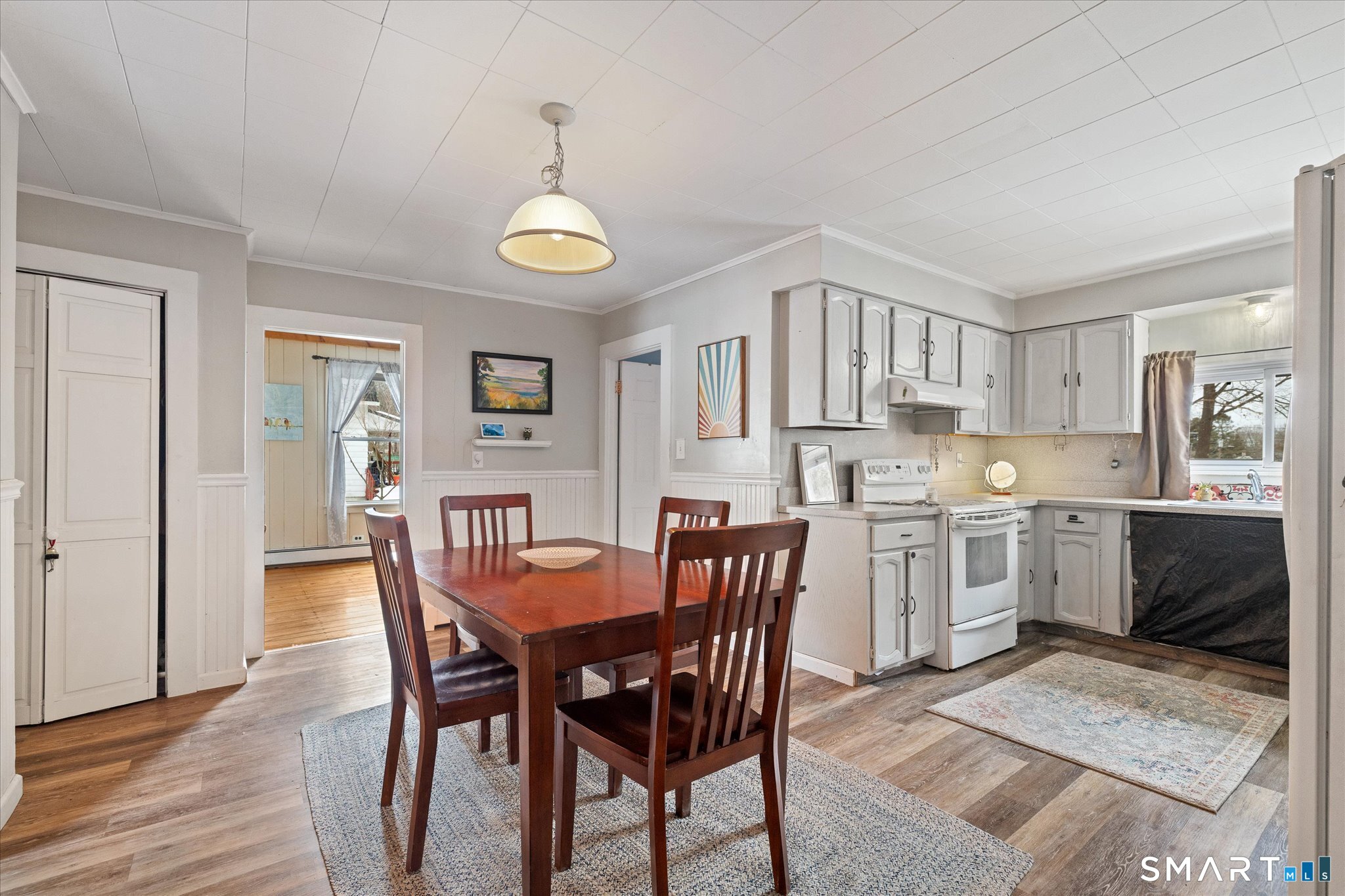 119 Quercus Avenue Windham, CT 06226 - Photo 17 of 30 a view of a dining room and livingroom with furniture wooden floor a rug and a chandelier