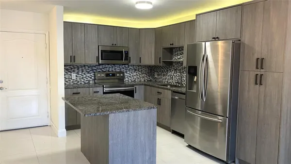 a kitchen with stainless steel appliances granite countertop a refrigerator and a stove