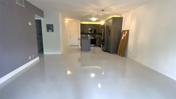 a view of a kitchen with refrigerator and chairs