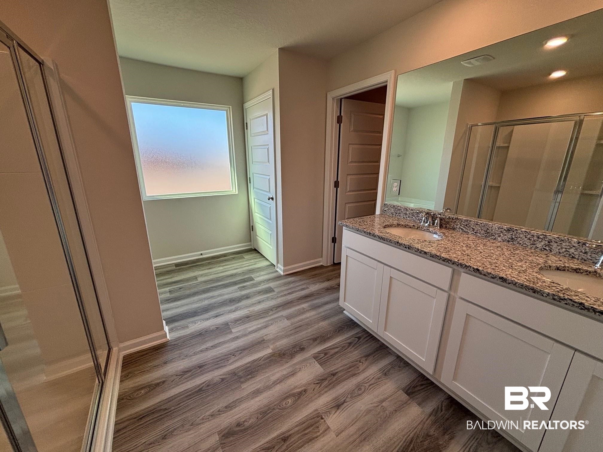 22044 Aleutian Avenue Foley, AL 36535 - Photo 14 of 28 Bathroom with a shower with door, vanity, and wood-type flooring