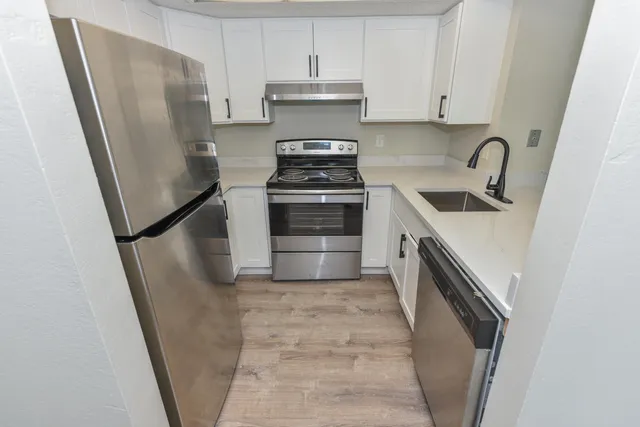 a kitchen with stainless steel appliances a stove a refrigerator and a sink