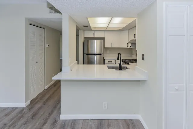 a kitchen with kitchen island a sink appliances and cabinets