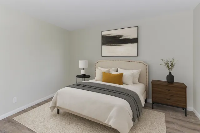 a bedroom with a bed and a painting on the wall