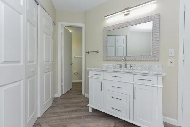a bathroom with a granite countertop sink and a mirror