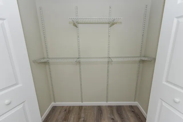 a view of walk in closet with wooden floor