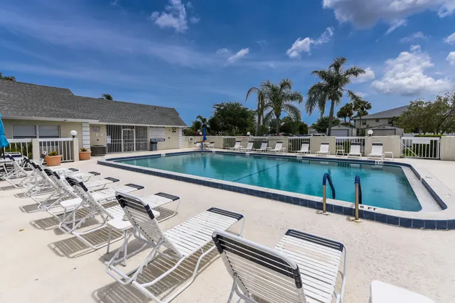 a view of swimming pool with outdoor seating and house in the background