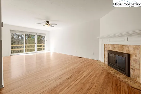 an empty room with windows and ceiling fan