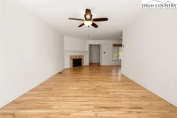 an empty room with a ceiling fan and a window