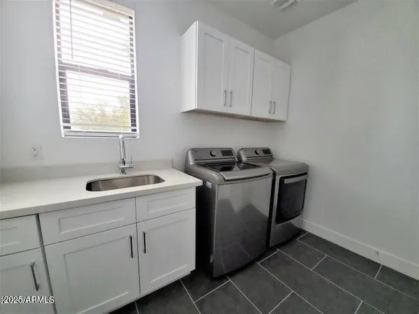 a utility room with cabinets washer and dryer