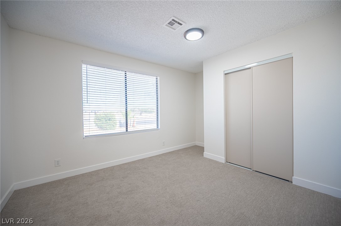 7041 North Decatur Boulevard Las Vegas, NV 89131 - Photo 22 of 33 A well-lit bedroom with soft carpeting offers a comfortable and neutral space.