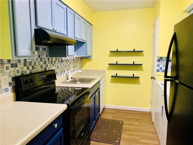 a kitchen with stainless steel appliances a stove a refrigerator and a sink