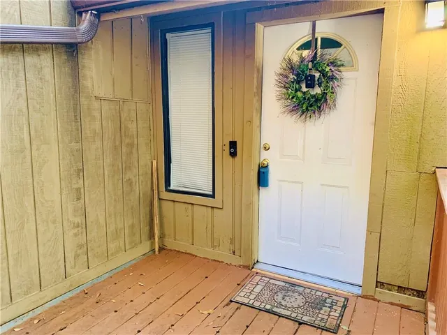 a view of a hallway with wooden floor and a bathroom