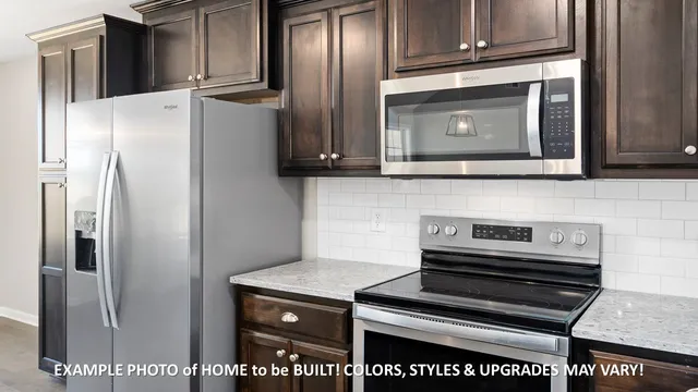 a kitchen with granite countertop a refrigerator stove and microwave