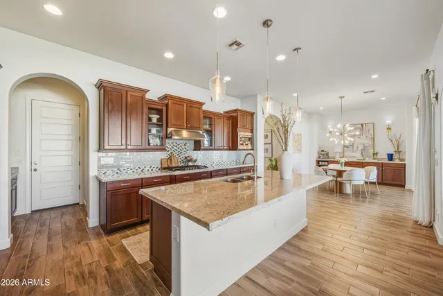 a large room with kitchen island a sink a stove and wooden floor