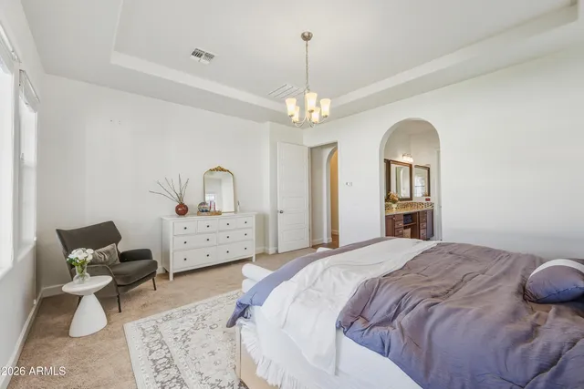 a bedroom with a bed and a chandelier