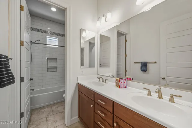 a bathroom with a double vanity sink mirror and shower