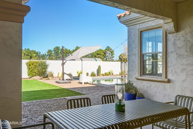 a view of a patio with table and chairs with wooden floor and fence