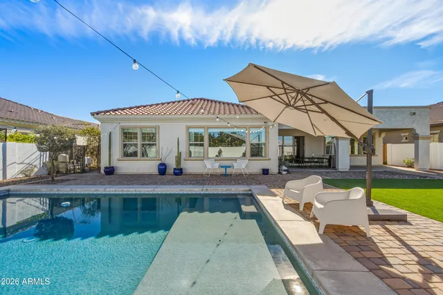 a front view of a house with swimming pool having outdoor seating