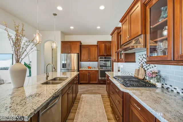 a kitchen with stainless steel appliances granite countertop a sink and stove