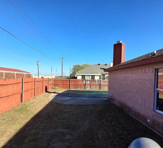 an empty room with windows and fireplace