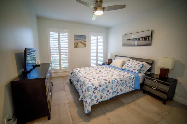 a bedroom with a bed and a flat tv screen on a dresser