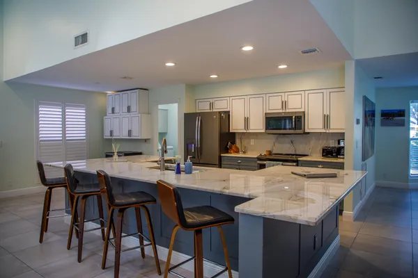 a kitchen with refrigerator and chairs