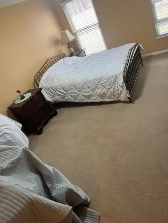 a bed sitting in a bedroom next to a window