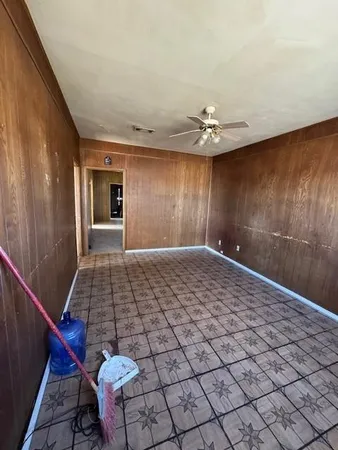a view of a livingroom with a chandelier fan and windows