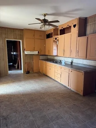 a large kitchen with granite countertop a sink and a cabinets