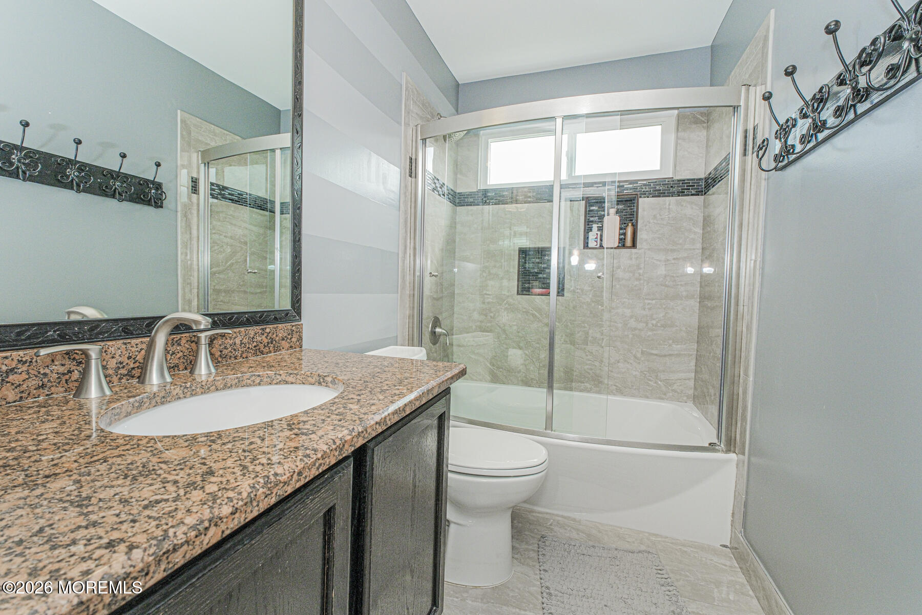 315 Wedgewood Road Morganville, NJ 07751 - Photo 27 of 37 a bathroom with a granite countertop sink a toilet a mirror and shower