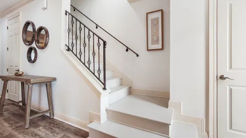 a view of staircase with lots of frames on wall and a window