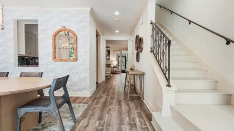 a view of a hallway with wooden floor windows and stairs