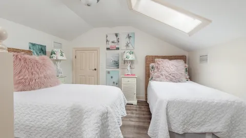 a bedroom with two bed and a window