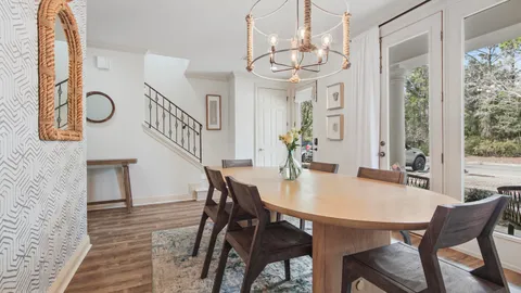 a view of a dining room with furniture a chandelier and wooden floor