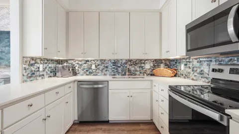 a kitchen with white cabinets and appliances