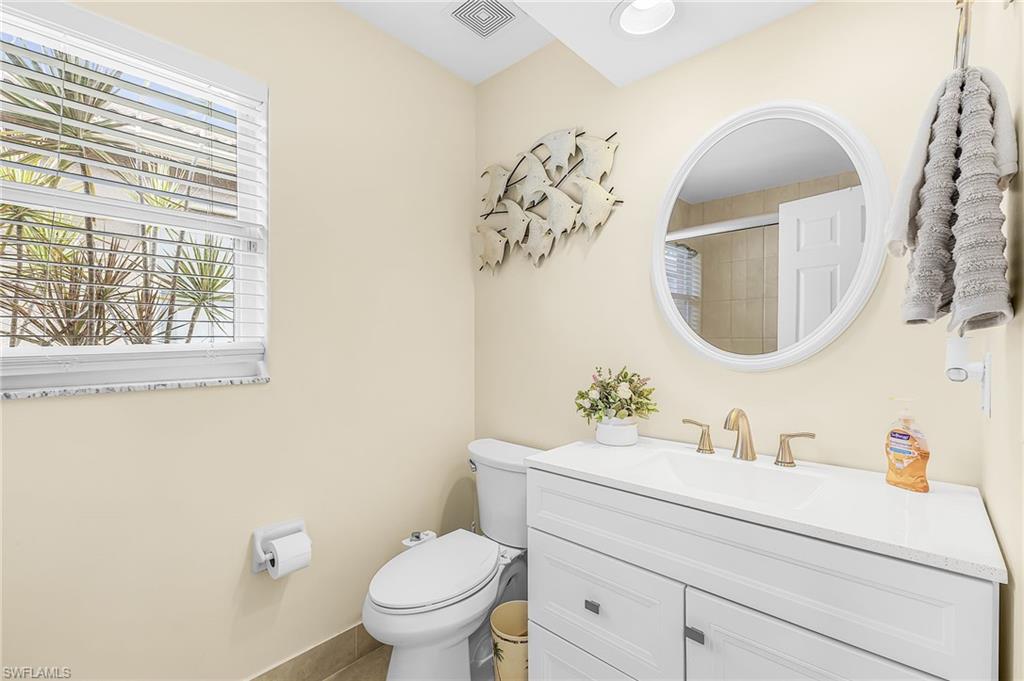 1415 Princess Sabal Point Naples, FL 34119 - Photo 18 of 42 White vanity with a white countertop and brass-finish faucet