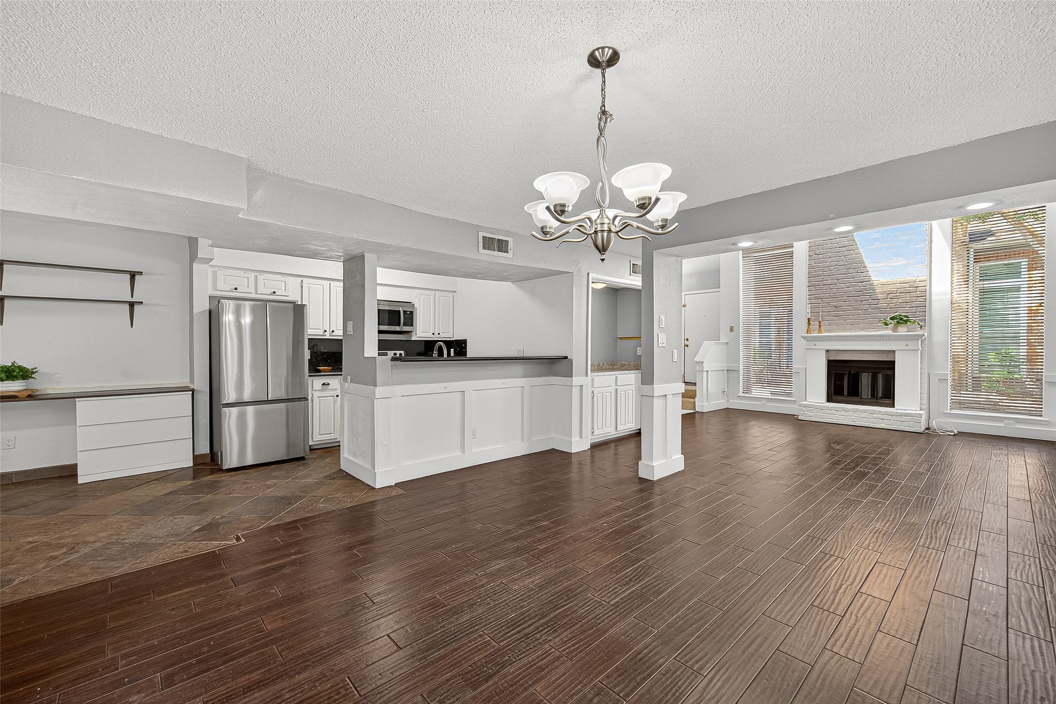 3200 South Gessner Road, Unit 224 Houston, TX 77063 - Photo 7 of 27 This spacious open-concept area features a modern kitchen with stainless steel appliances, a cozy living room with a fireplace, and large windows for ample natural light.