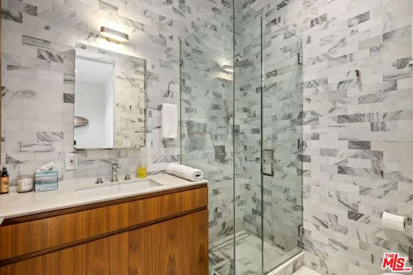 a bathroom with a sink mirror and shower