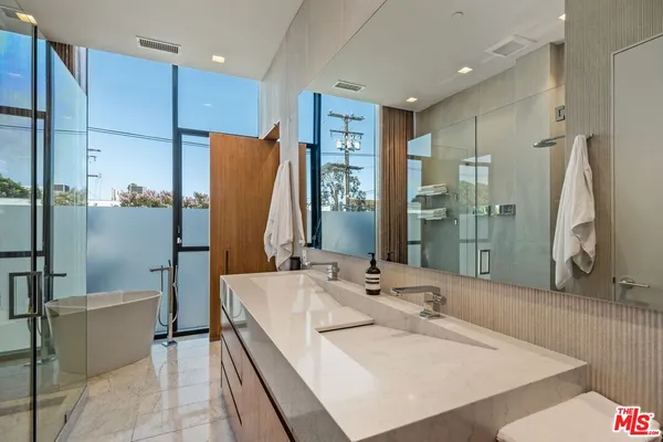 a bathroom with a tub sink and mirror