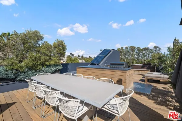a roof deck with table and chairs