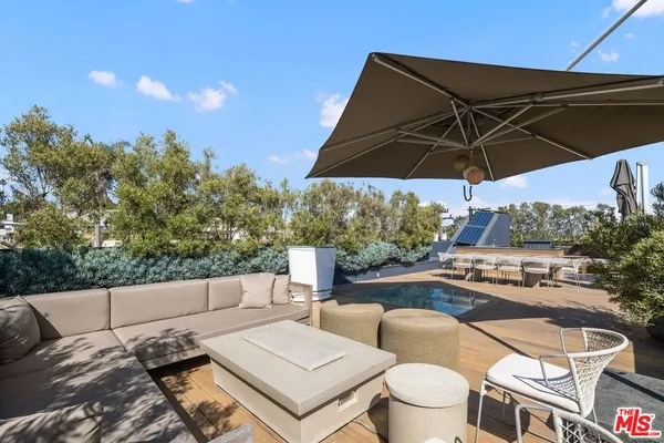 a view of a patio with a table and chairs under an umbrella